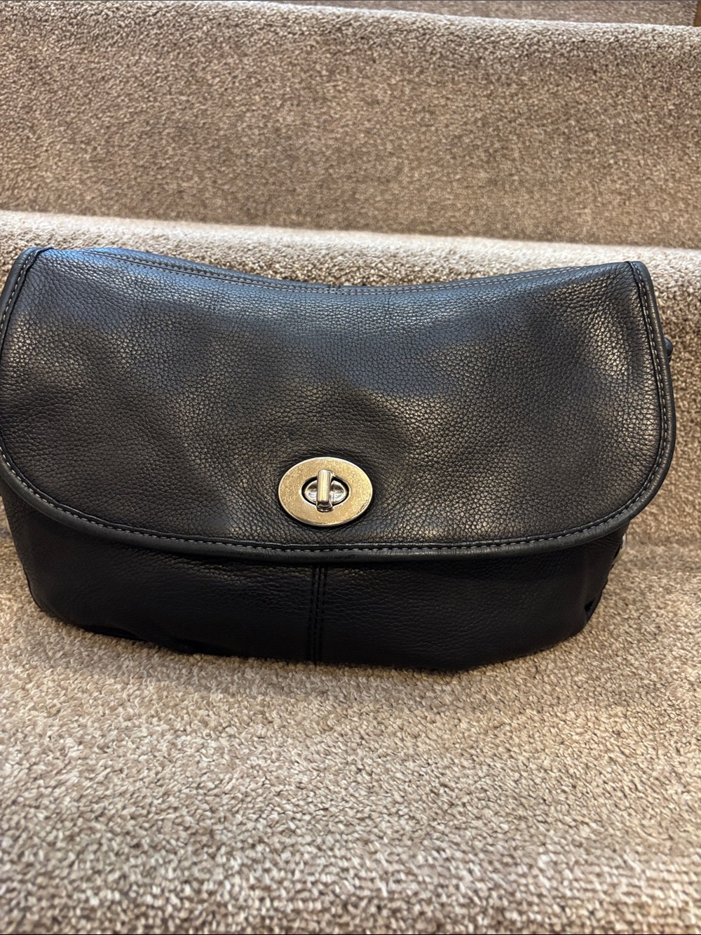 This is a vintage black pebbled leather Coach Legacy flap bag